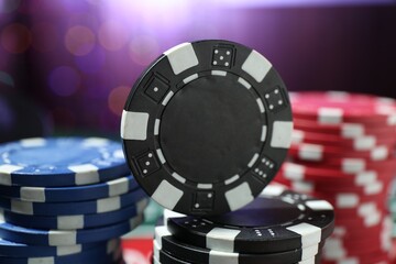 Casino chips against blurred lights, closeup view