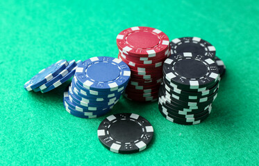 Stacks of casino chips on green table, closeup