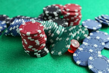 Casino chips and die on green table, closeup