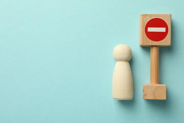 Unemployment. Human figure and stop sign on light blue background, top view. Space for text