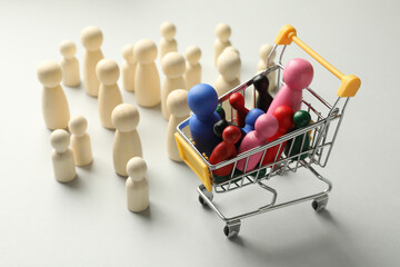 Unemployment. Many different human figures and mini cart on light background, closeup