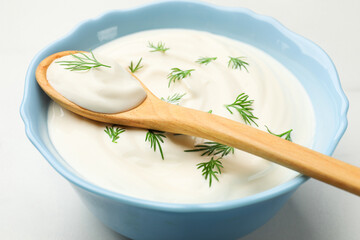 Tasty sour cream with dill on white table, closeup