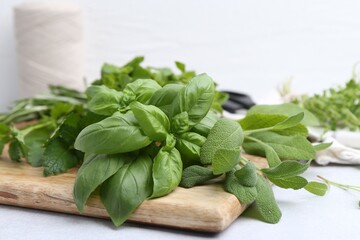 Different fresh green herbs on light table, closeup