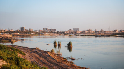 View of the Tigris River in Baghdad Iraq with city skyline in the background during sunset