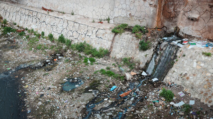 Waste accumulation near a water source in Baghdad Iraq highlighting environmental concerns