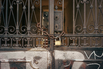 A padlock with a chain on an old rusty gate
