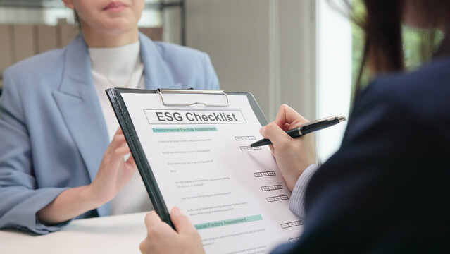 Asian female audit ESG risk check list paper form net zero waste supply chain vendor eco go green carbon credit control. Asia people woman give advice report prepare work review best practice process.