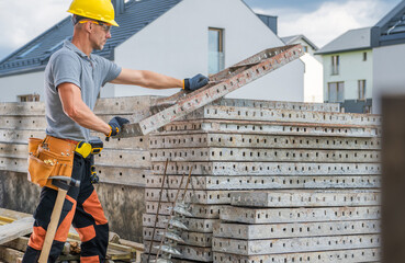 Construction Worker Arranging Concrete Slabs on a Building Site in a Residential Area