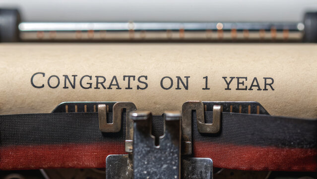 Happy Work Anniversary and thank you. Vintage typewriter with the message "Congrats on 1 year" displayed on its paper.