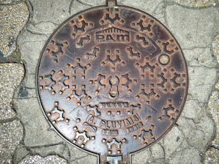 Circular manhole cover on stone pavement