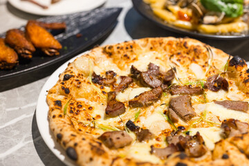 Freshly baked pork pizza with melted cheese