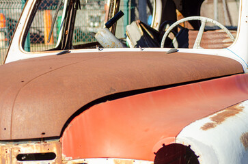 The Top of a Rusty Car with a White Steering Wheel. Concept A glimpse into a forgotten interior.