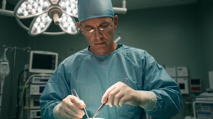 Focused male surgeon performing surgery in a modern operating room. Doctor in scrubs and gloves using surgical instruments during a medical procedure.