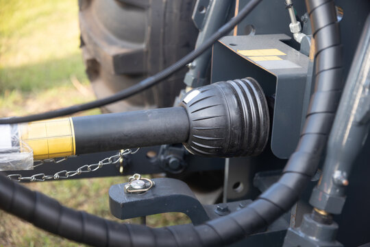 Rear end of farm tractor showing the PTO shaft and three point hitch  is used to connect agricultural implements.