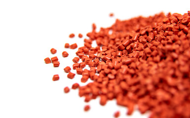 Red plastic polymer granules isolated on white
