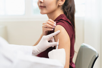 People getting a vaccination to prevent pandemic concept. Woman in medical face mask  receiving a...