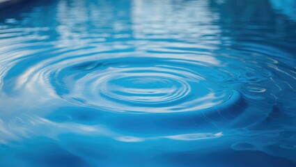 Close-up of water ripples with blue tones, illustrating the effect of a droplet falling into the water.