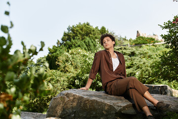 Stylish young man enjoying a sunny day in a lush green park setting