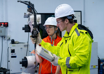 Engineers collaborate on robotic automation in a modern manufacturing facility during training...