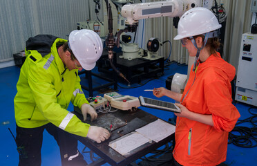 Engineers collaborate on robotics project in modern workshop with advanced technology