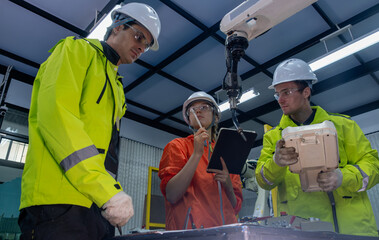 Engineers collaborating on a robotics project in a modern facility during daylight