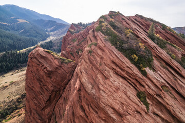 Stunning aerial view of red rock formations in Charyn Canyon, Kazakhstan.  Layers of textured sandstone create a dramatic landscape, showcasing the power of nature and erosion. Breathtaking scenery