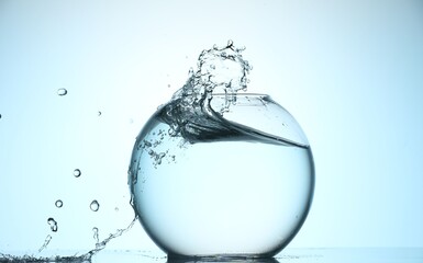 Glass aquarium with water on light blue background