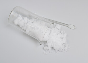 Magnesium nitrate powder on light grey background.