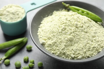 Protein powder and green peas on grey table, closeup