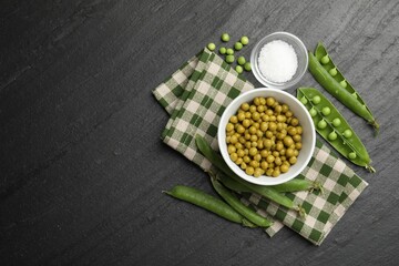 Pickled peas, salt and pods on black table, flat lay. Space for text