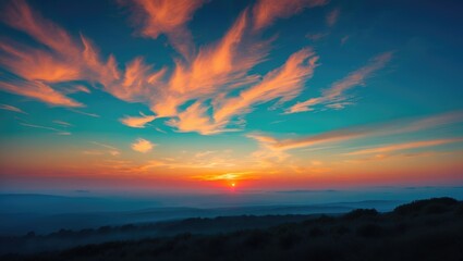 Fototapeta premium A sunrise over a landscape with colorful clouds in the sky during early morning.