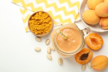 Superfood. Tasty smoothie and ingredients on white table, flat lay. Space for text