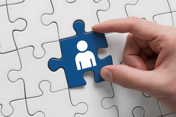 A close up image of a hand placing a blue jigsaw puzzle piece with a person icon on a white puzzle board.