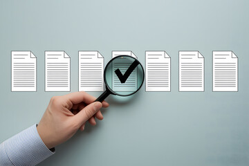 A hand holds a magnifying glass over a document marked with a checkmark, highlighting it from other documents.