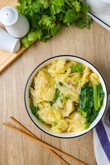 Wonton with bok choy Soup in a ceramic bowl	
