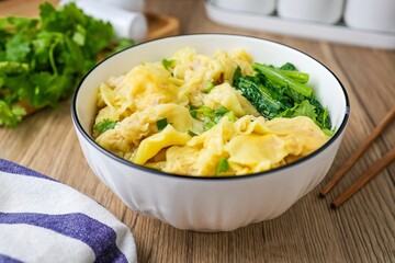 Wonton with bok choy Soup in a ceramic bowl	