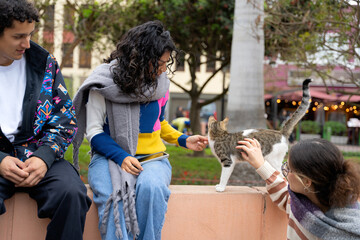 Young tourists petting a cat while exploring the city