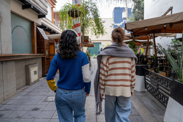 Two friends walking down a city street, enjoying their time together