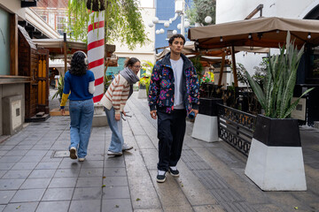 Friends attracted to a stylish boy walking near them in urban setting