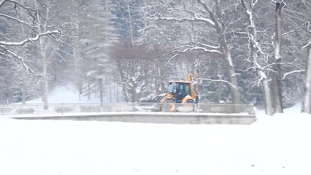 Tractor removes clean snow from the road Element Snow Hurricane Utilities Cleaning Snow