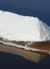 Sea salt production. Fleur de sel - salt flakes. Mount of organic fleur de sel recently skimmed from the surface. Drying out in the Algarve sunshine. Faro, Portugal.
