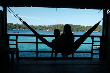 Couple Silhouetted in Hammock Overlooking Tropical Ocean
