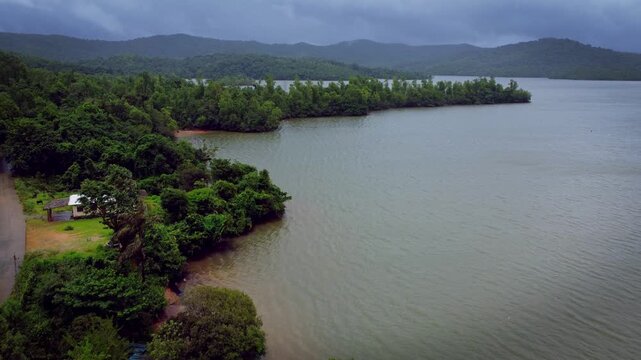 Serene aerial view of Sharavathi River backwaters during monsoon in Karnataka, India &mdash; tranquil waters meeting lush greenery under dramatic monsoon skies