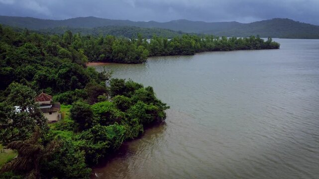 Serene aerial view of Sharavathi River backwaters during monsoon in Karnataka, India &mdash; tranquil waters meeting lush greenery under dramatic monsoon skies
