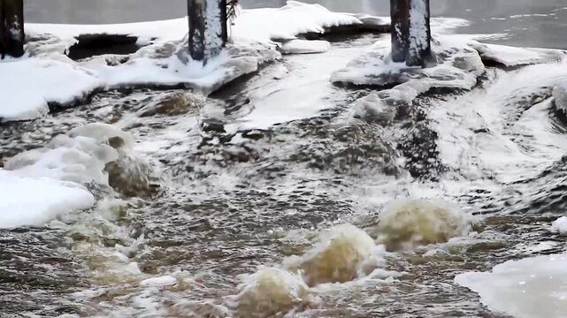 Ice drift on the river, water flow and blocks of ice .Bridge supports under pressure from ice drift Pieces of ice float on the river