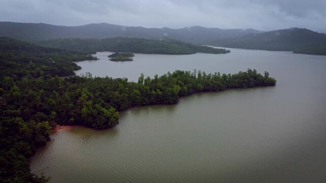 Serene aerial view of Sharavathi River backwaters during monsoon in Karnataka, India &mdash; tranquil waters meeting lush greenery under dramatic monsoon skies