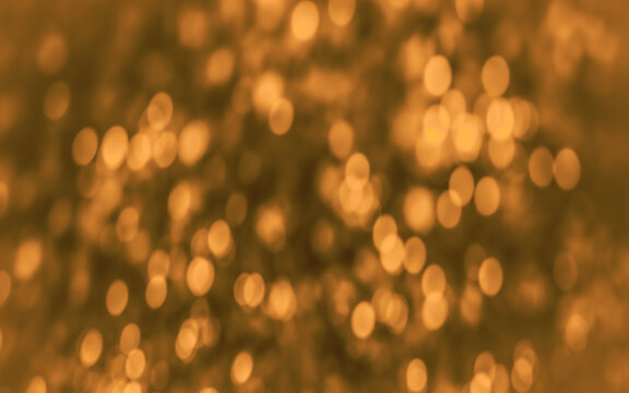 abstract gold and amber bokeh background with glowing orbs. shimmering festive random pattern holiday backdrop.