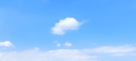Blue sky background with white clouds in summer. Soft white clouds float in the clear blue sky. Clear blue sky, bright spring, soft sky gradient, wallpaper landscape, aerial view.