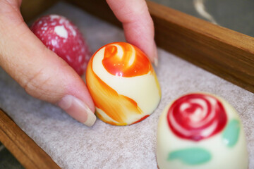 Woman's Fingers Picking an Exquisite Chocolate Bonbon
