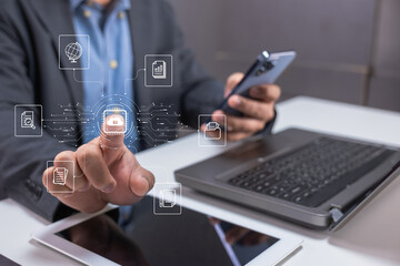 A person interacts with virtual icons of digital files and security on a touchscreen, with laptop,...